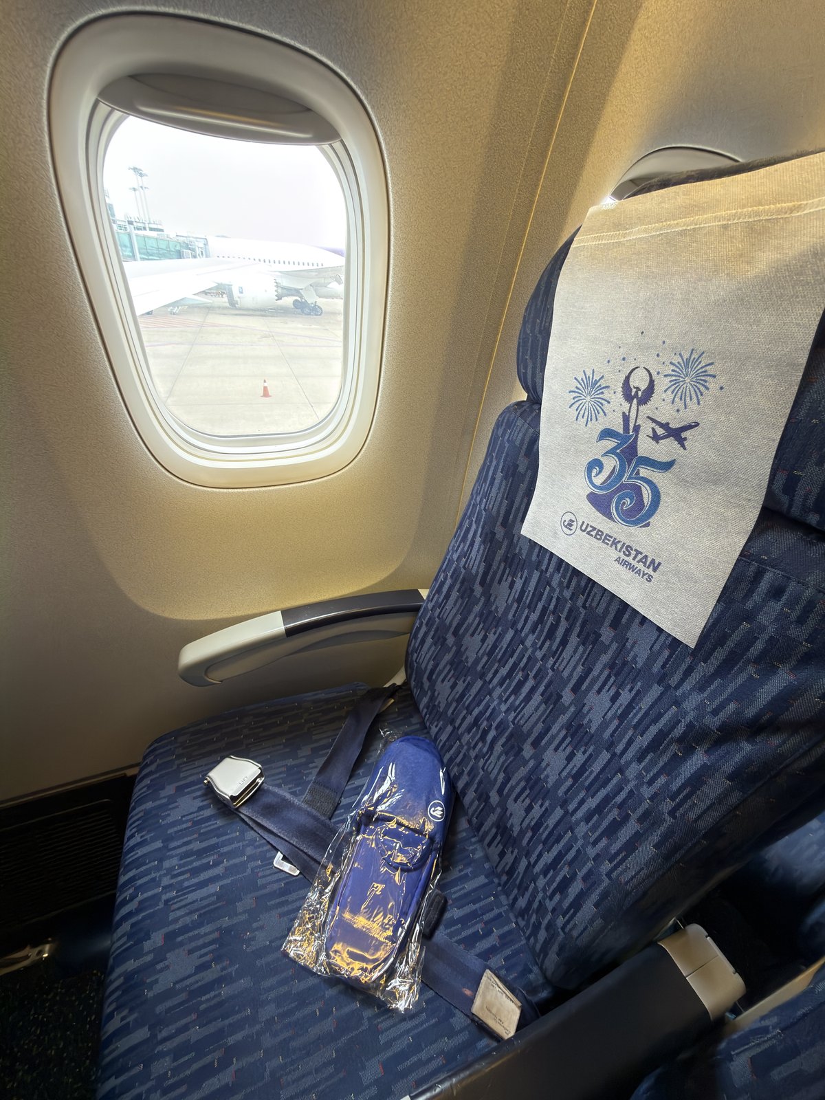 烏茲別克航空機艙座位上的 35 週年紀念毯與拖鞋