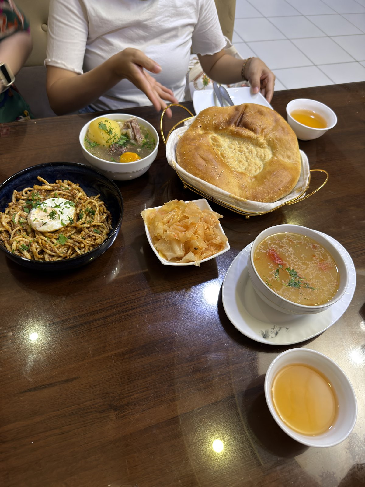 餐桌上的烏茲別克湯品、炒麵、麵包與泡菜